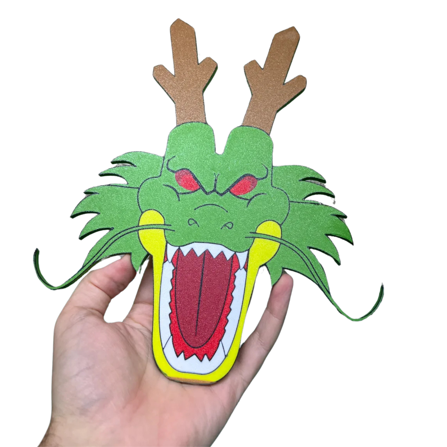 Mano sosteniendo la parte frontal del aplique decorativo de la cabeza de Shenlong de Dragon Ball, resaltando los detalles de su rostro y boca abierta.