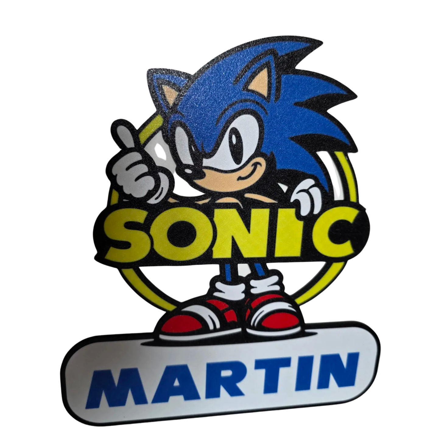 Adorno decorativo de Sonic the Hedgehog en su clásico diseño azul y rojo, con la frase "SONIC" y el nombre "MARTIN" en una base blanca.