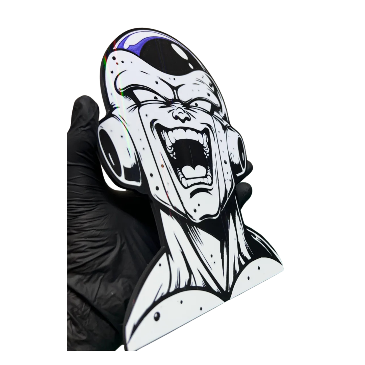 Aplique decorativo de Freezer de Dragon Ball Z, visto desde un ángulo, mostrando el brillo holográfico sobre su cabeza y mejillas, sostenido por una mano.