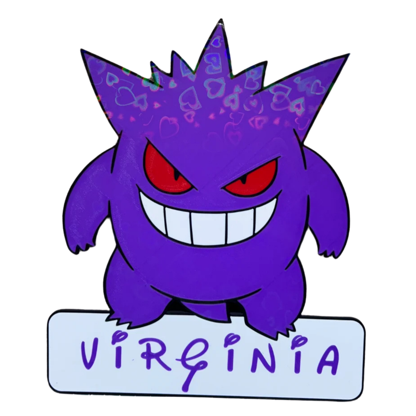 Aplique decorativo de Gengar Pokémon de color morado, mostrando un patrón de corazones y figuras en su cuerpo, con el nombre "VIRGINIA" en su base.