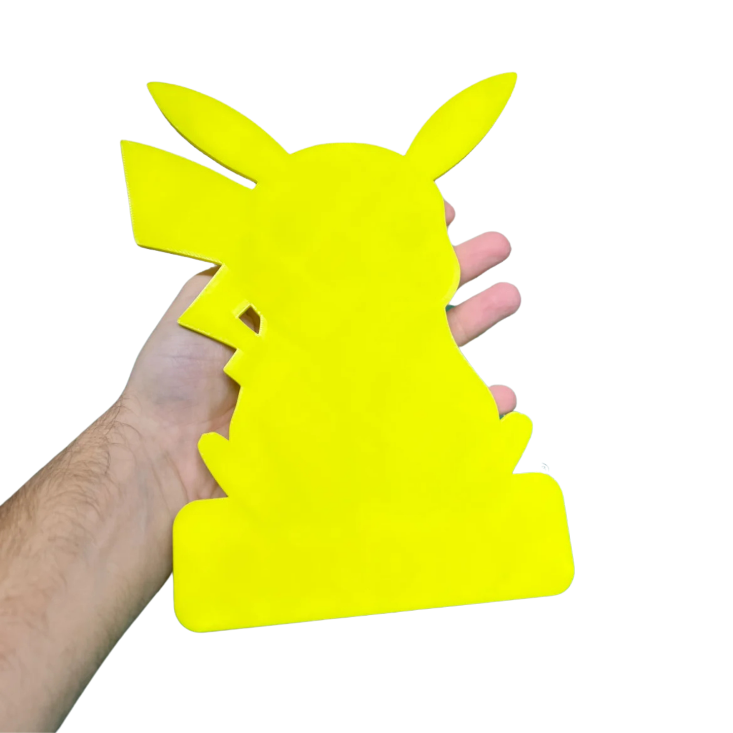 Mano sosteniendo la parte trasera de un aplique decorativo de Pikachu Pokémon, mostrando el color amarillo liso del reverso.