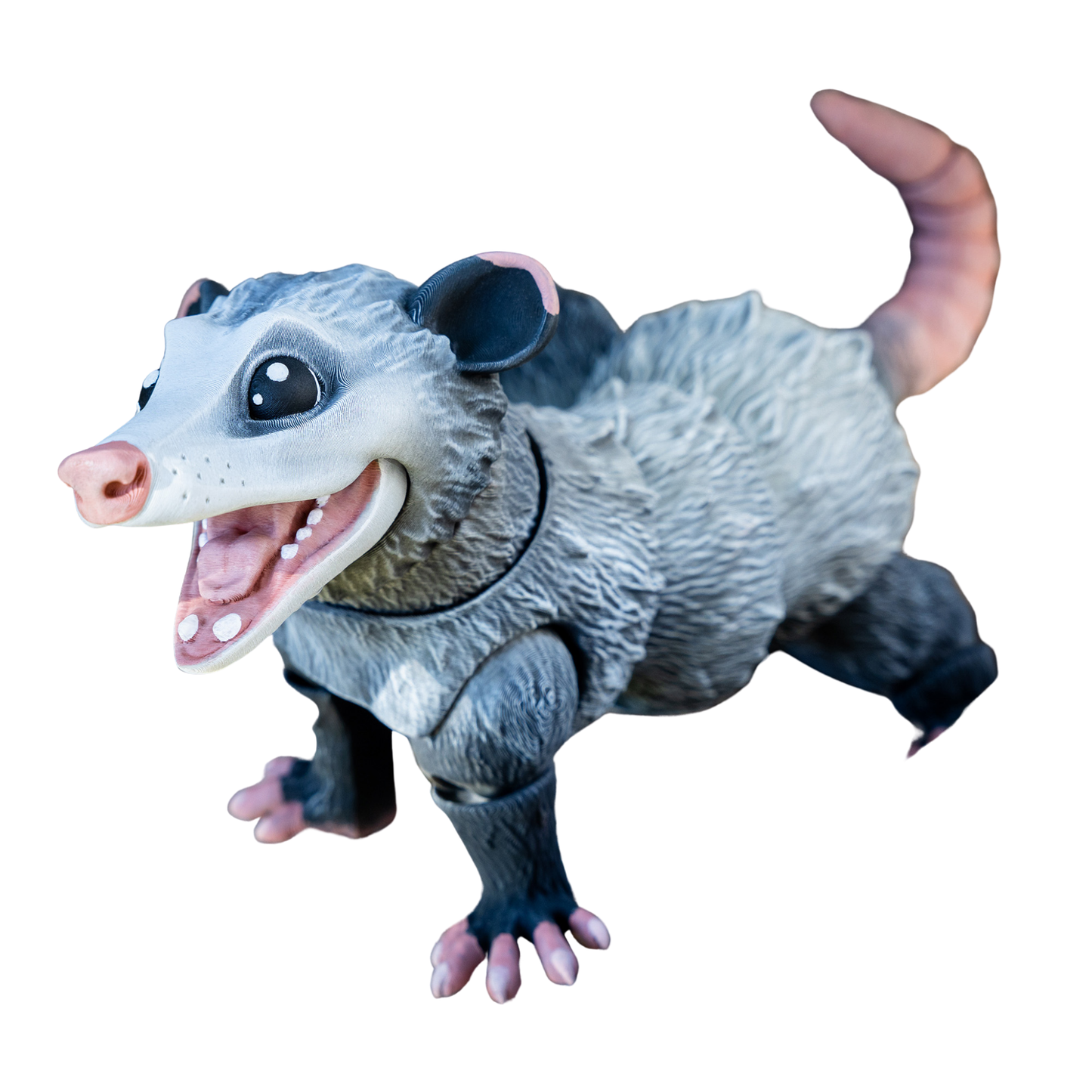 Figura articulada de zarigüeya en color gris, con boca abierta y una pata levantada en una pose dinámica o de movimiento.