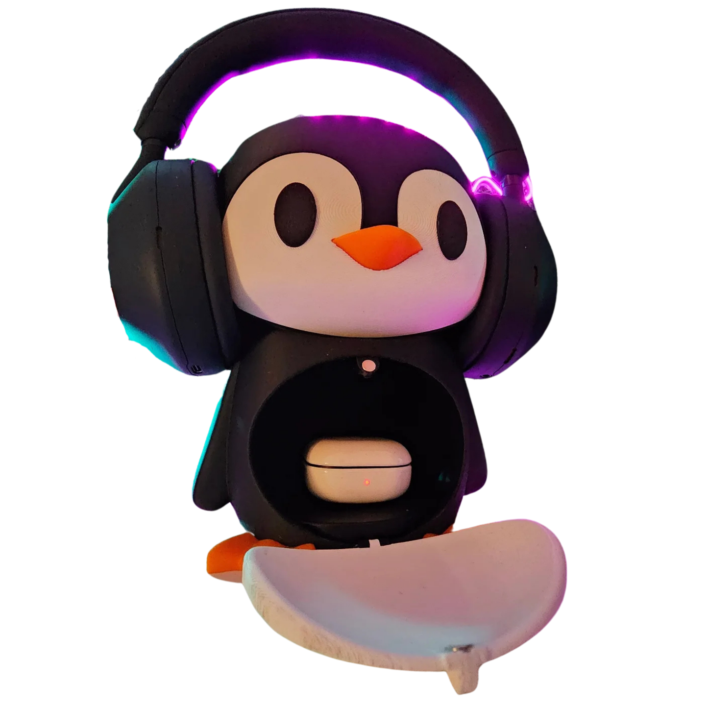 Soporte para audífonos con diseño de pingüino, mostrando un headset negro y un estuche de auriculares inalámbricos blancos con una luz roja dentro de su compartimento, sobre una base blanca.