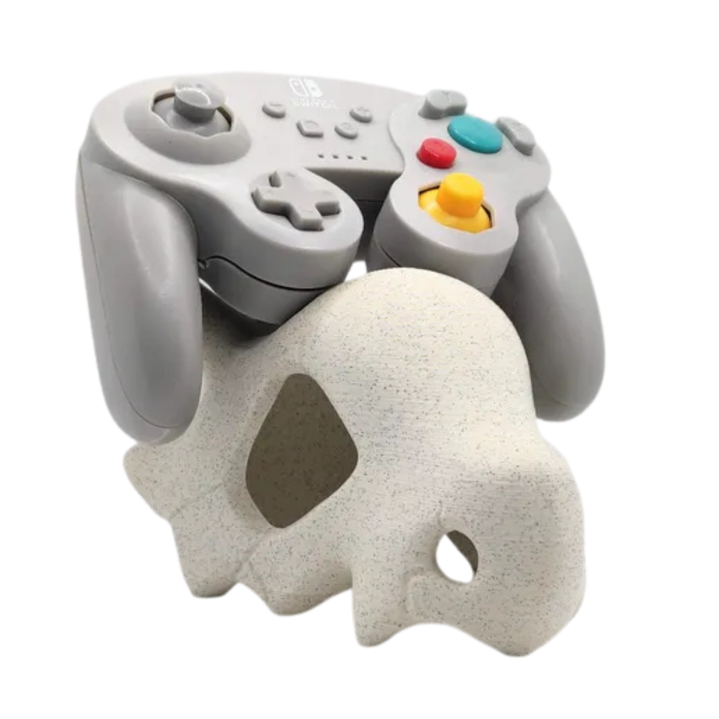 Soporte de mando Cubone (Pokémon) con textura tipo piedra, sosteniendo un mando estilo GameCube gris, sobre fondo blanco.