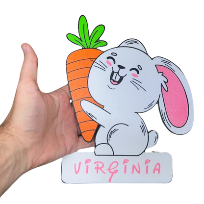 Aplique decorativo infantil de conejito blanco sonriente con una zanahoria y el nombre "personalizado" en la base, ideal para un cuarto de niños.
