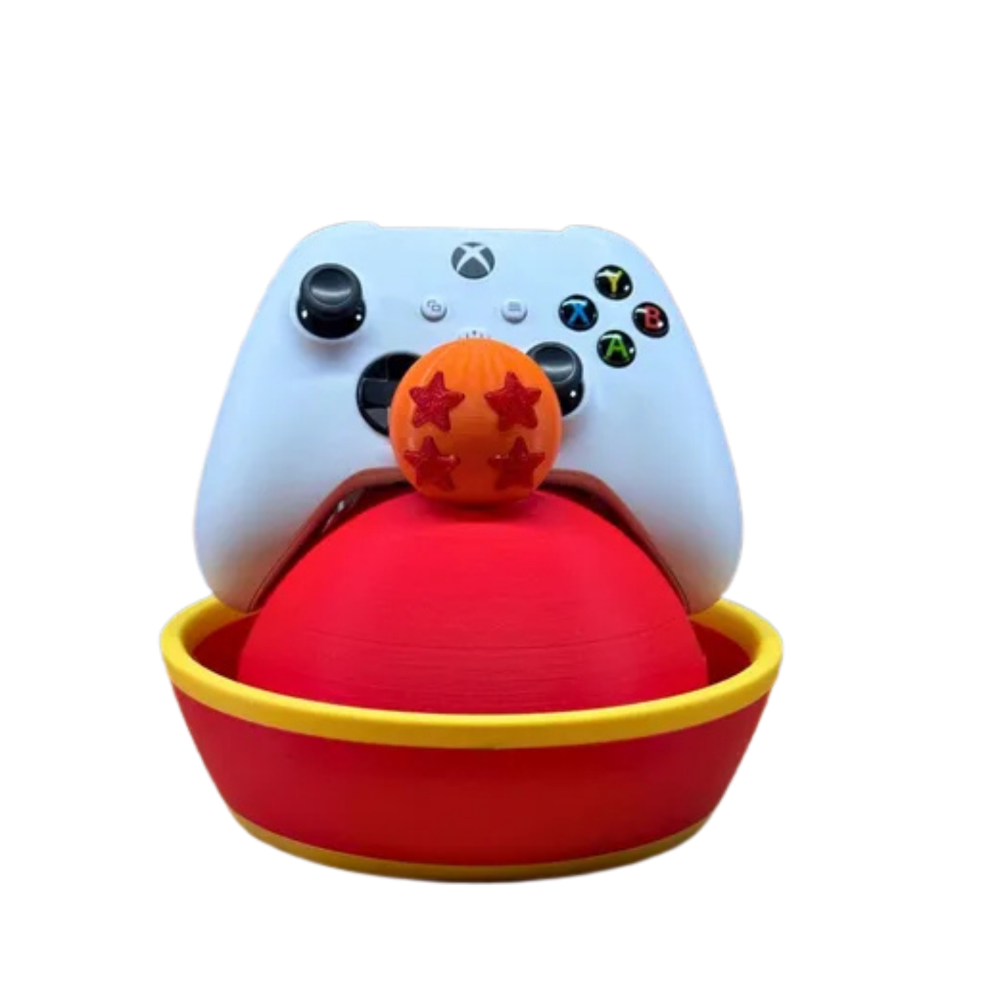 Base para controlador con diseño del sombrero de Gohan de Dragon Ball Z (rojo y amarillo), con Esfera del Dragón de 4 estrellas naranja y un mando de Xbox blanco, sobre un fondo con textura de ladrillo.