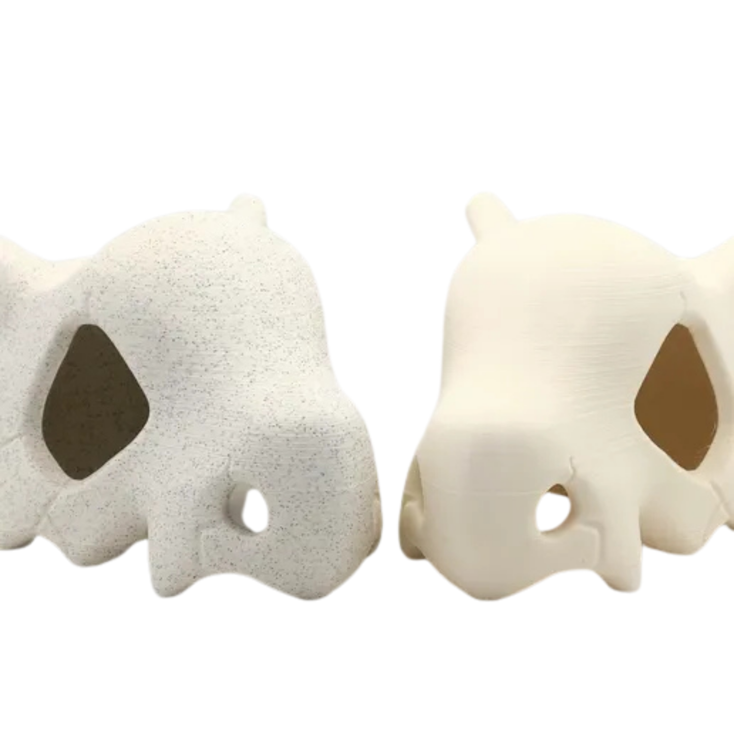 Dos figuras decorativas de calavera de Cubone (Pokémon) vacías, mostrando las diferencias entre el acabado liso y el texturizado tipo piedra.