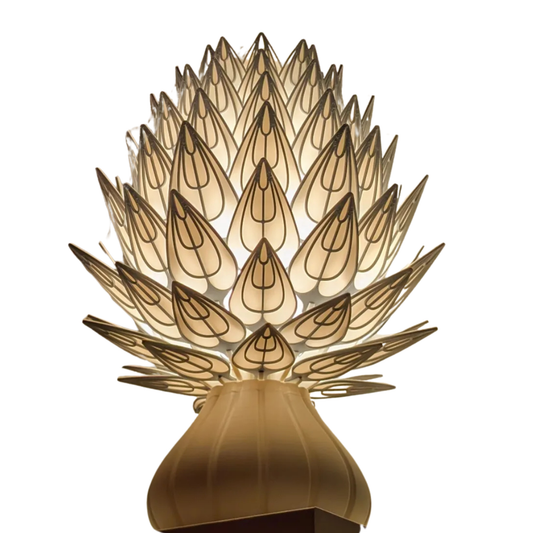 Pantalla de lámpara con diseño de prisma floral en tonos claros con contornos oscuros, montada sobre una base, creando una forma de alcachofa o piña luminosa.