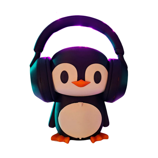 Porta audífonos con forma de pingüino kawaii en blanco y negro con pico y patas naranjas, sosteniendo un headset negro en su cabeza.