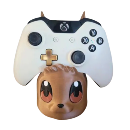 Porta mando Eevee de Pokémon con un control de Xbox blanco, visto de frente, mostrando la mirada tierna de Eevee.