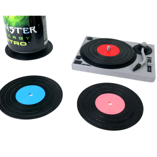 Set de posavasos de disco de vinilo retro y organizador tocadiscos en miniatura, con una lata de bebida Monster y dos posavasos sueltos (azul y rosa).