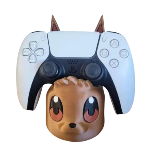 Soporte de mando gaming con diseño de la cabeza de Eevee (Pokémon) en color marrón, sosteniendo un control de PS5 blanco.