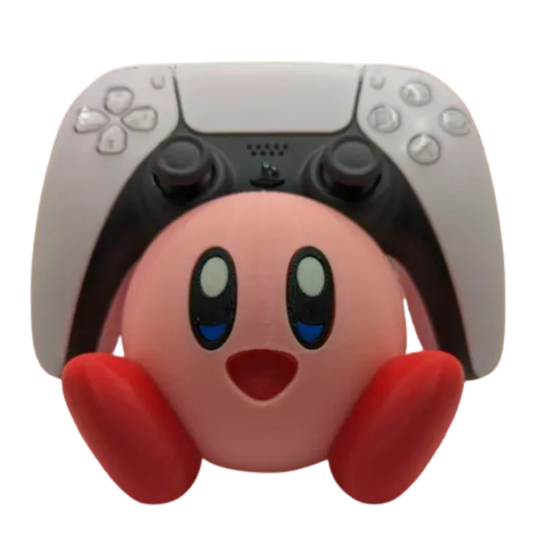 Soporte de mando gaming Kirby de Nintendo, sosteniendo un control de PS5 blanco, sobre un fondo rosa suave, mostrando su compatibilidad con la nueva generación.