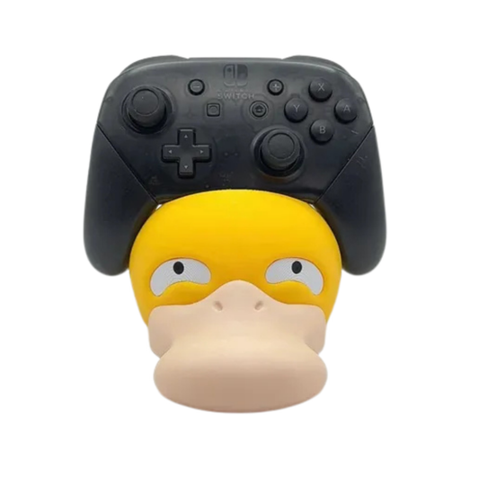 Soporte de mando gaming con diseño de la cabeza de Psyduck de Pokémon en amarillo y pico beige, sosteniendo un Nintendo Switch Pro Controller negro.