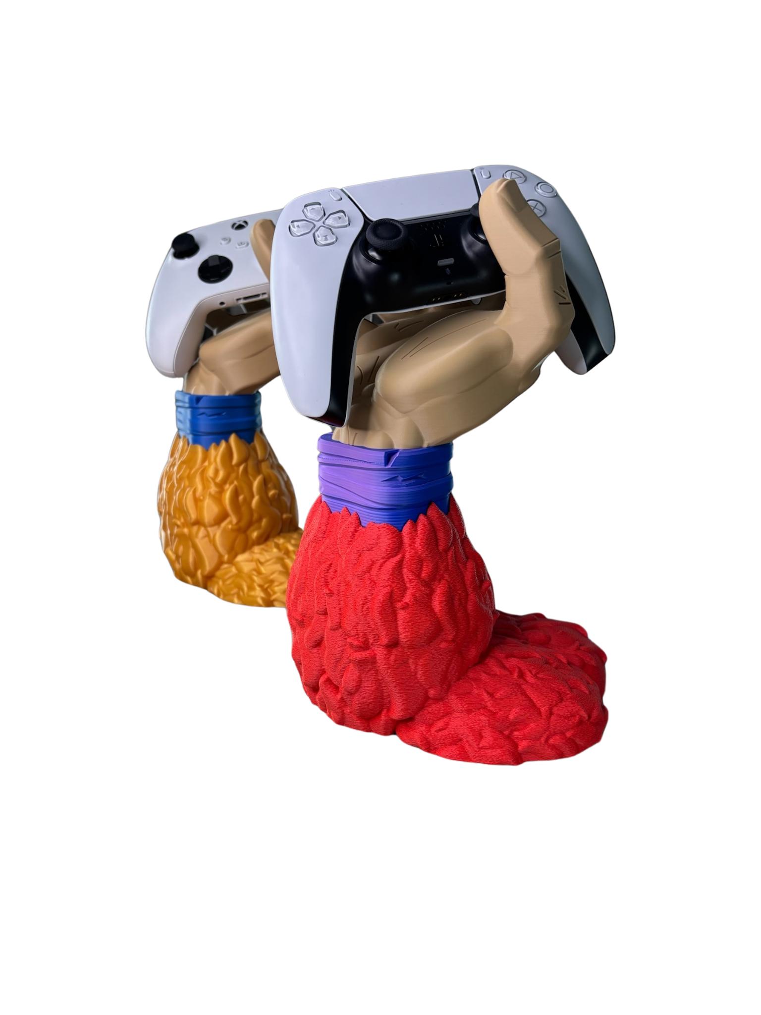 Dos soportes de mando de Goku Super Saiyajin 4 (DBGT), uno con pelaje rojo sosteniendo un PS5 y otro con pelaje dorado/marrón con un Xbox, mostrando variedad de colores.