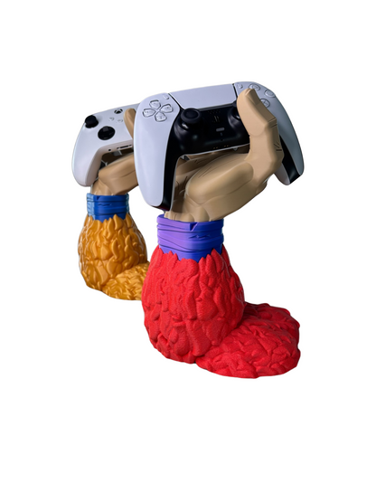 Dos soportes de mando de Goku Super Saiyajin 4 (DBGT), uno con pelaje rojo sosteniendo un PS5 y otro con pelaje dorado/marrón con un Xbox, mostrando variedad de colores.