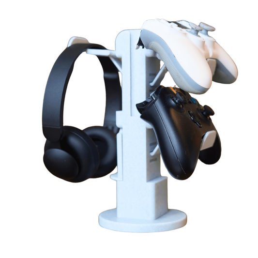 Torre organizadora de mandos gaming universal en color blanco, con un mando de PS5, un mando de Xbox y unos auriculares negros colgados, mostrando su capacidad.
