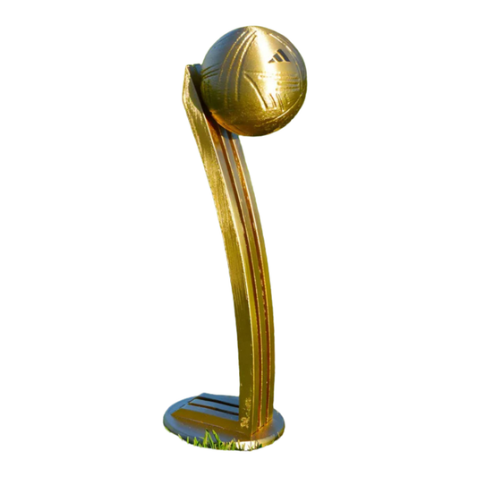 Trofeo réplica del Balón de Oro al mejor jugador del Mundial, con un balón de fútbol dorado sobre una base curvada y brillante.